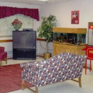A cozy living room featuring a television, fish tank, and patterned sofa.