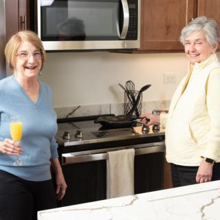 Two women enjoying time together in the kitchen.