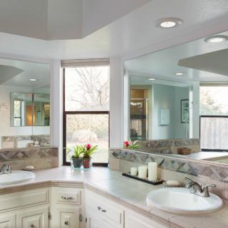 A modern bathroom with large mirrors and stylish sinks.