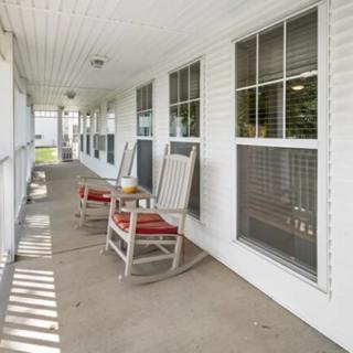 A cozy porch with rocking chairs and large windows.