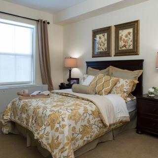 A cozy and well-decorated bedroom with floral bedding and soft lighting.