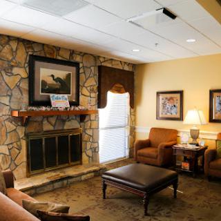 A cozy lounge area featuring a stone fireplace and comfortable seating.