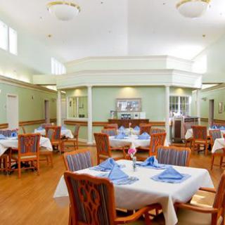 A bright and spacious dining room with neatly arranged tables and chairs.