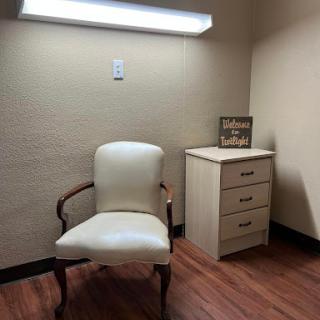 A simple office space featuring a chair and a small cabinet.