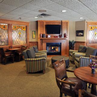 A cozy lounge area featuring a fireplace, comfortable seating, and a television.