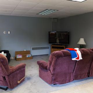 A cozy living room setup with a sofa, armchairs, and a television.
