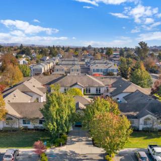 Aerial view of a suburban residential neighborhood with homes and trees under a cloudy sky.