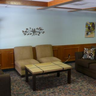 A cozy living room with comfortable seating and decorative wall art.