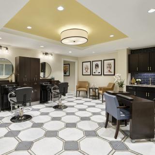 Modern salon interior with stylish furnishings and geometric tile flooring.