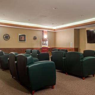 A cozy lounge area with comfortable armchairs and a wall-mounted television.