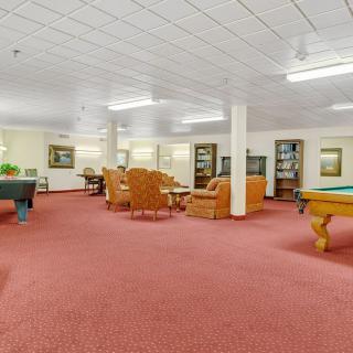A spacious recreation room with pool tables and comfortable seating.