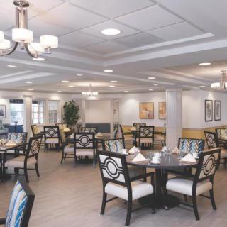 A spacious and elegantly decorated dining area with multiple tables and chairs.