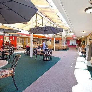 A pleasant outdoor seating area with umbrellas and a pathway in a commercial setting.