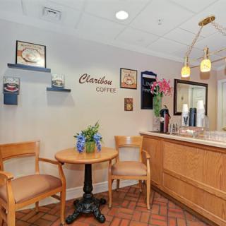 A cozy restaurant interior featuring a small seating area with wooden chairs and decorative elements on the walls.