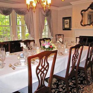 A formal dining room with an elegantly set table and classic decor.