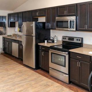 Modern kitchen with stainless steel appliances and dark wood cabinets.