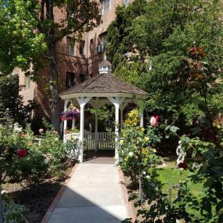 A charming gazebo surrounded by lush greenery and vibrant flowers in a garden setting.