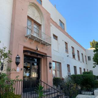 A charming two-story building featuring a mix of pastel colors and architectural details.