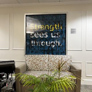 A cozy living space featuring inspirational artwork that reads 'Strength Lies Within.'