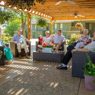 A group of seniors enjoying an outdoor gathering on a patio.
