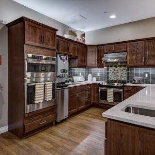A modern kitchen featuring wooden cabinets, stainless steel appliances, and sleek countertops.