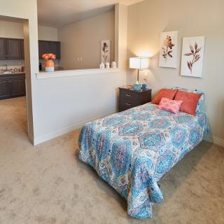 A cozy bedroom with a single bed, vibrant bedding, and stylish decor.