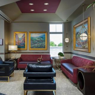 A modern living room with stylish sofas, framed artwork, and elegant lighting fixtures.
