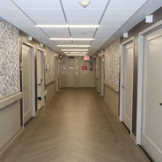 A view of a modern hallway featuring multiple doors and decorative wall patterns.