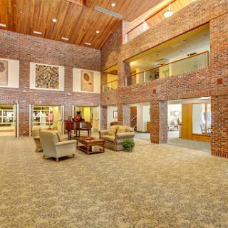A spacious and modern lobby featuring brick walls, comfortable seating, and decorative art.