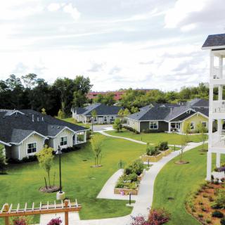 A serene residential area with neatly landscaped gardens and pathways connecting several houses.