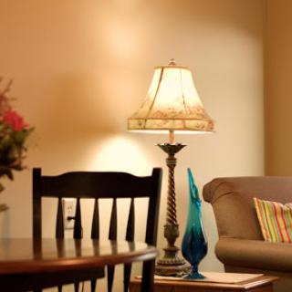 A cozy living room setup featuring a lamp, a comfortable sofa, and decorative touches.