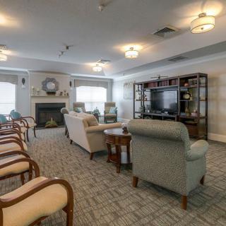 A cozy living room featuring comfortable seating, a fireplace, and a television.