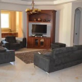 Spacious living room with a TV and comfortable seating arrangement.