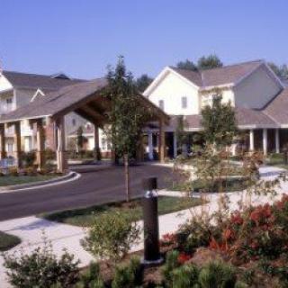 A suburban residential building with well-maintained landscaping and a driveway.