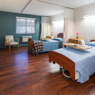 A hospital room with two beds and medical equipment.