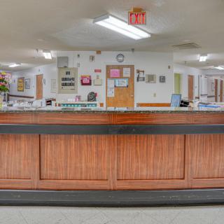 A spacious reception area with a wooden counter and office decor.