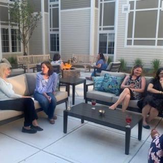 A group of people enjoying a casual conversation on a patio.