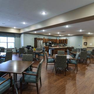 Spacious and well-lit dining area with tables and chairs arranged for communal gatherings.