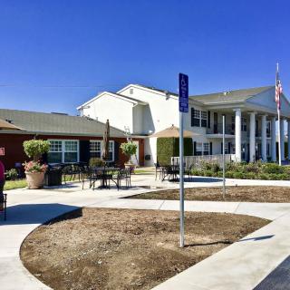 A sunny day at a modern building with landscaped surroundings and outdoor seating.