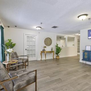A modern and welcoming lobby area featuring comfortable seating, decorative plants, and a reception desk.