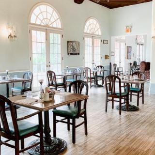Bright and airy restaurant interior with wooden tables and chairs.