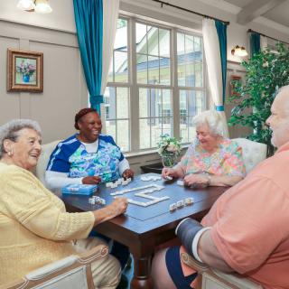 A group of seniors enjoying a card game in a nursing home.