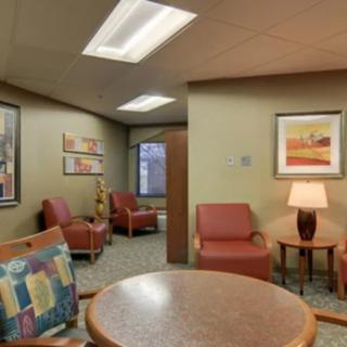 A cozy waiting room with comfortable seating and decorative artwork.