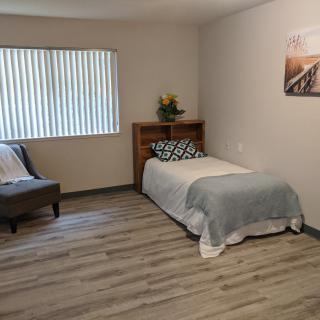 A minimalist bedroom with a single bed and simple decor.