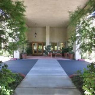 A view of a building entrance framed by lush greenery.
