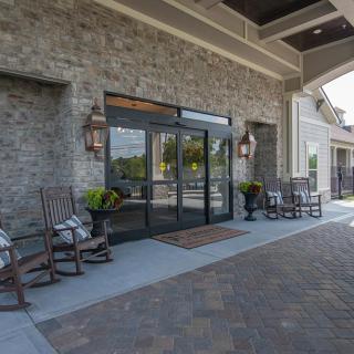 A welcoming building entrance with seating and decorative plants.