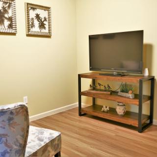 A cozy living room corner featuring a television on a stylish stand with decorative elements.