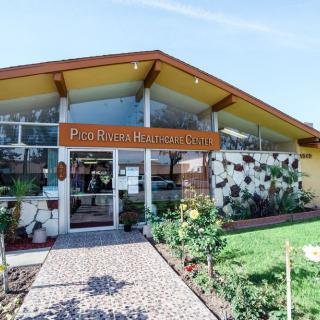 A mid-century modern motel with distinctive architecture and neatly landscaped surroundings.