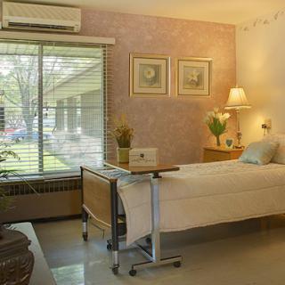 A serene and comfortable hospital room with natural light and tasteful decor.