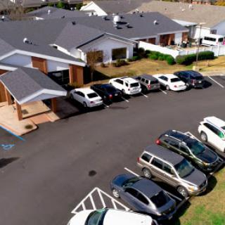 An aerial view of a residential complex with a parking lot filled with various vehicles.